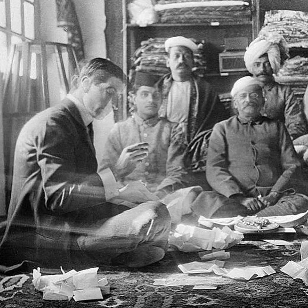 Black and white: Jacques Cartier and Indian men on floor, examining jewels and papers.