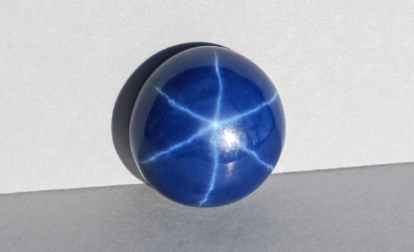 A star sapphire cut en cabochon — the smooth, domed cut that allows the asterism to appear at the surface